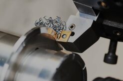 Texas manufacturing news today: CNC lathe operator reviewing production data showing capacity surge